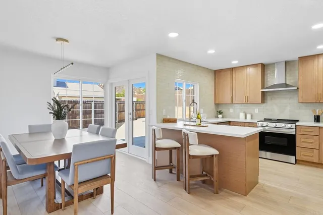 a kitchen with a dining table chairs and stove