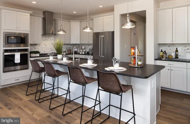 a kitchen with stainless steel appliances kitchen island a sink refrigerator and cabinets