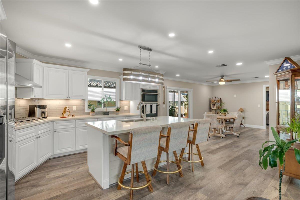 8 Spring Lane, Unit 8 Morgan Hill, CA 95037 - Photo 4 of 23 a kitchen with cabinets a sink dishwasher a island with chairs and wooden floor