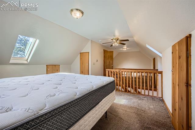 365 Alpine View Road Divide, CO 80814 - Photo 16 of 26 Bedroom with lofted ceiling with skylight, ceiling fan, and carpet flooring