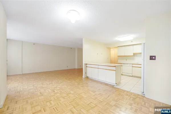 a view of an empty room with cabinet and a window