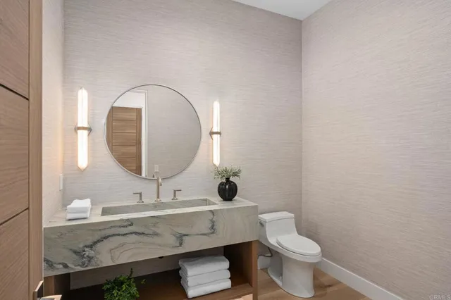 a bathroom with a toilet a sink and mirror