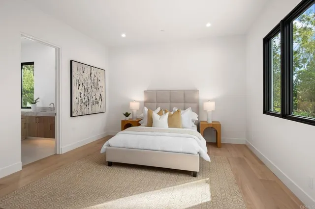 a bedroom with a bed and large windows