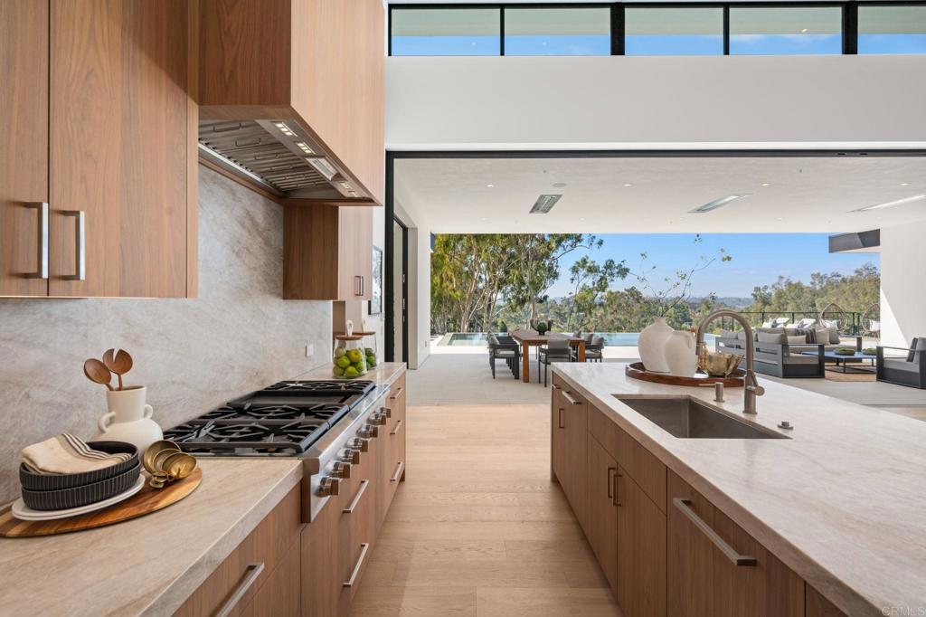 5471-73 La Crescenta Road Rancho Santa Fe, CA 92067 - Photo 4 of 23 a kitchen with stainless steel appliances a sink stove and cabinets