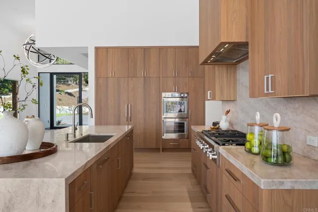 a kitchen with stainless steel appliances a sink stove and cabinets