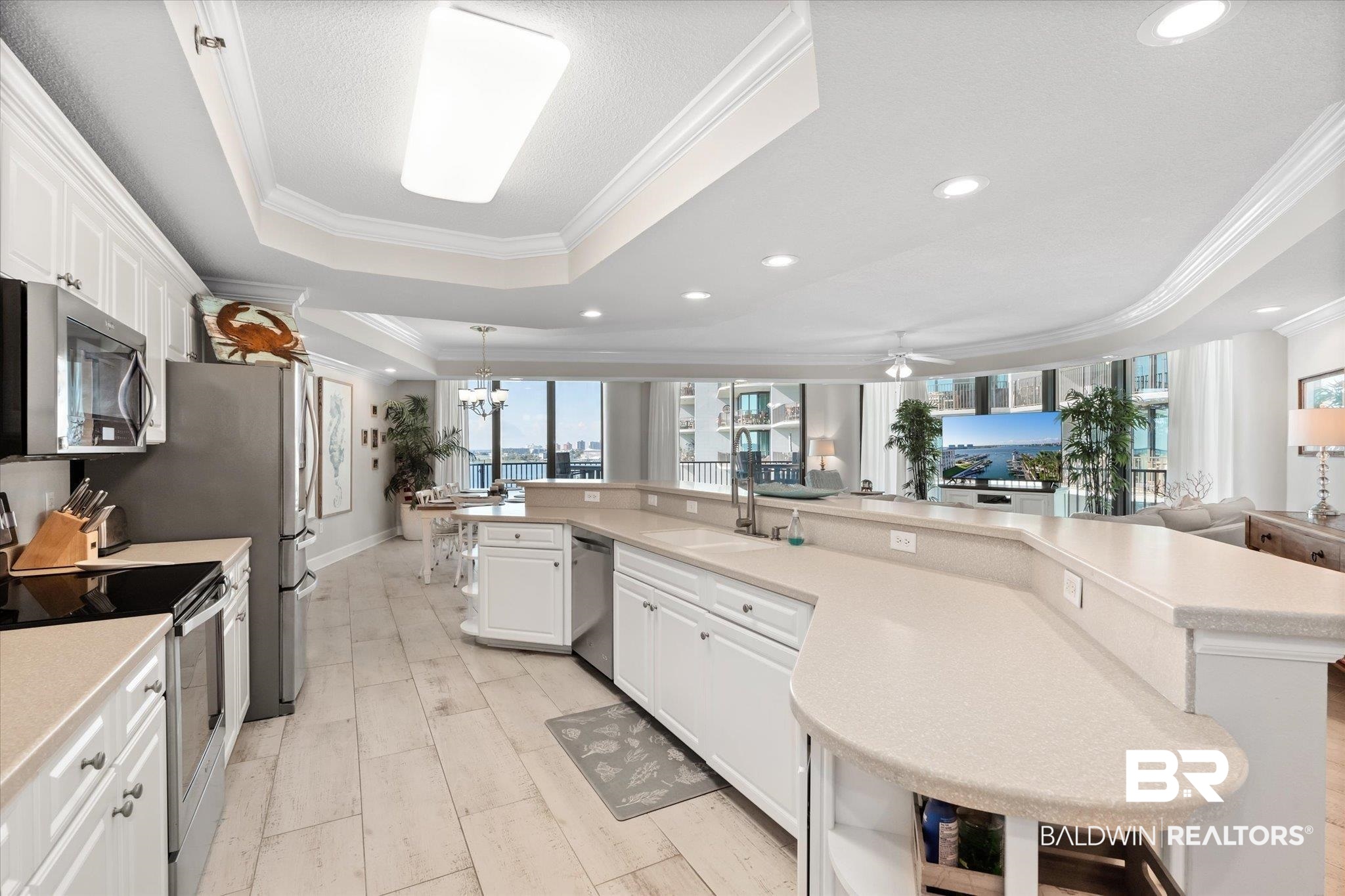 27582 Canal Road, Unit 2611 Orange Beach, AL 36561 - Photo 8 of 37 Kitchen featuring ceiling fan, appliances with stainless steel finishes, a tray ceiling, and white cabinetry