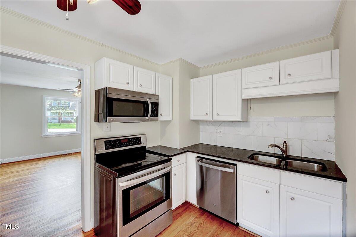 829 Colleton Road Raleigh, NC 27610 - Photo 13 of 27 a kitchen with white cabinets and appliances