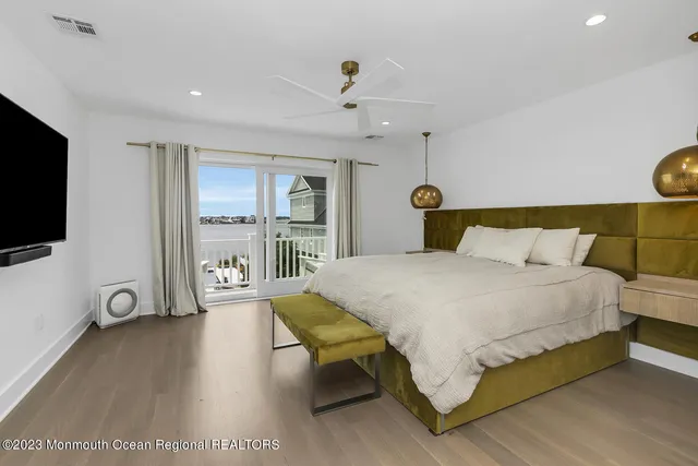 a spacious bedroom with a bed and a flat screen tv