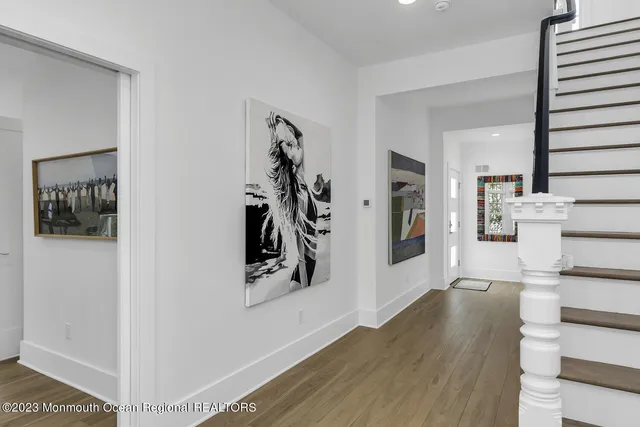a view of a hallway with wooden floor and dining room
