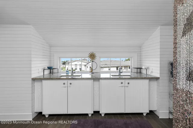 a kitchen with granite countertop white cabinets and sink