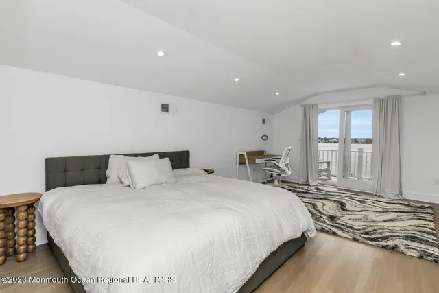 a large bed sitting in a bedroom next to a window
