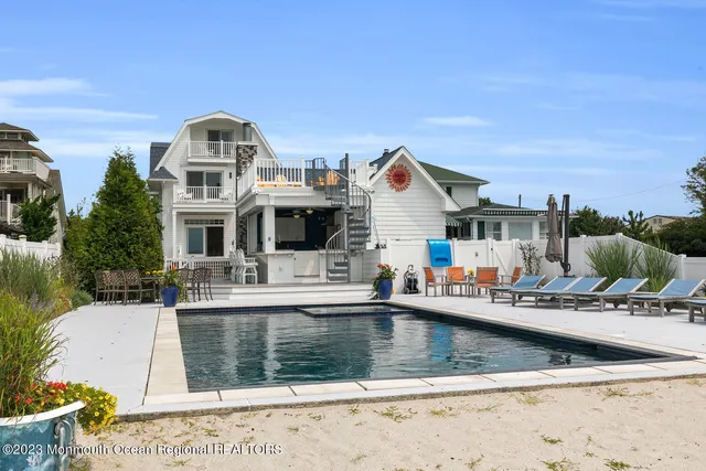 a view of a house with pool and chairs