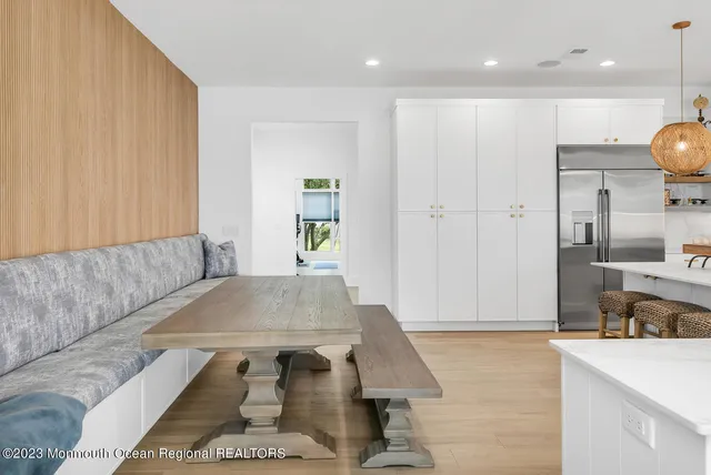 a living room with a couch and kitchen view with wooden floor