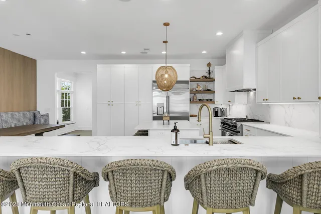 a kitchen with stainless steel appliances kitchen island granite countertop a sink and a white cabinets