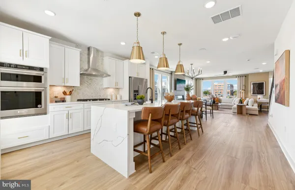 a open kitchen view with stainless steel appliances granite countertop a stove and a wooden floors