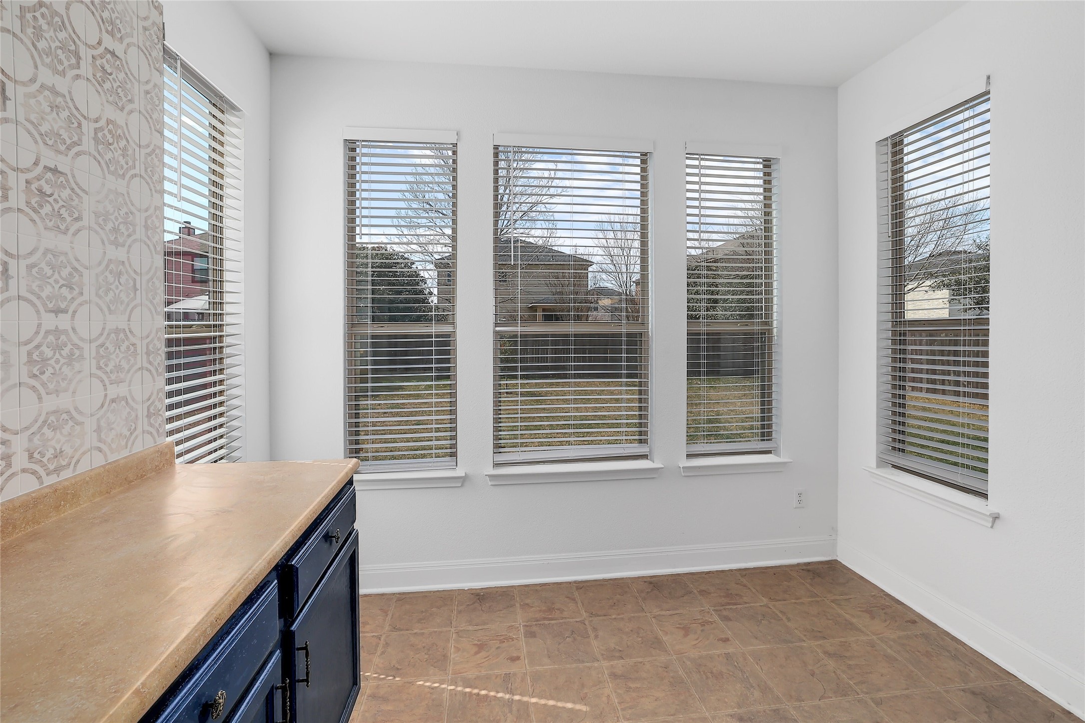 203 Ran Road Leander, TX 78641 - Photo 11 of 31 A sunny dining nook features durable tile flooring and views through large windows.