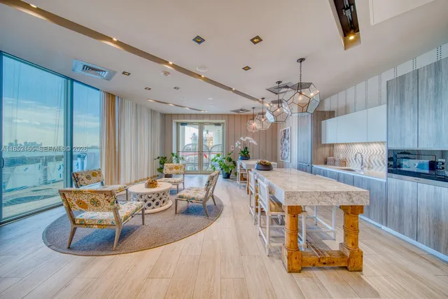 a living room with furniture a large window and wooden floor
