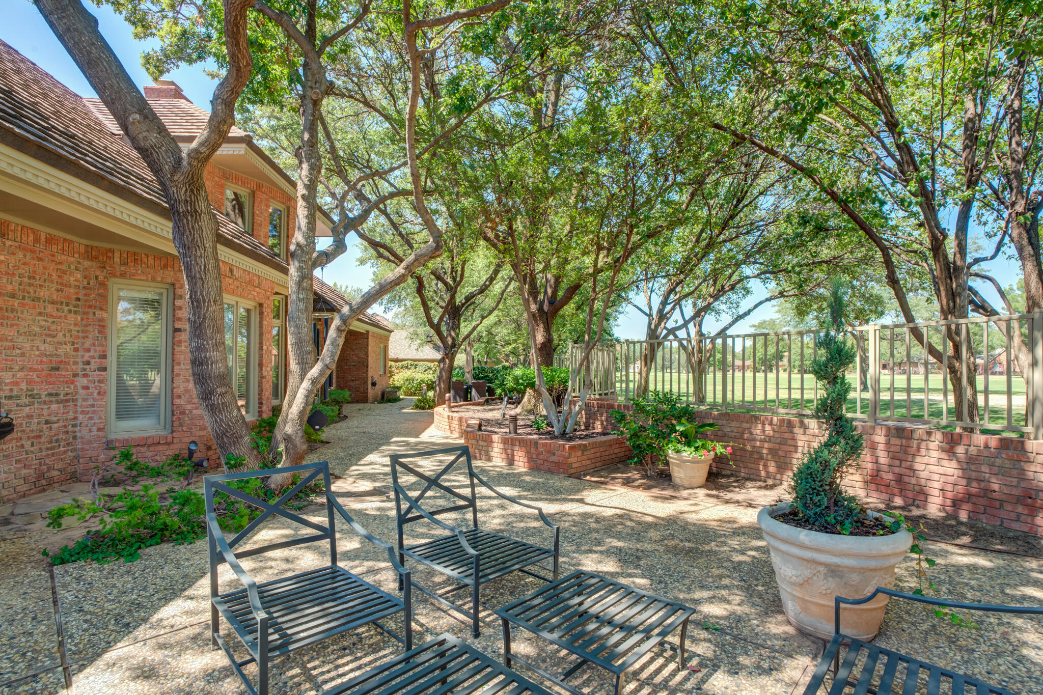 4612 91st Street Lubbock, TX 79424 - Photo 76 of 83 a view of a patio with table and chairs potted plants and large tree