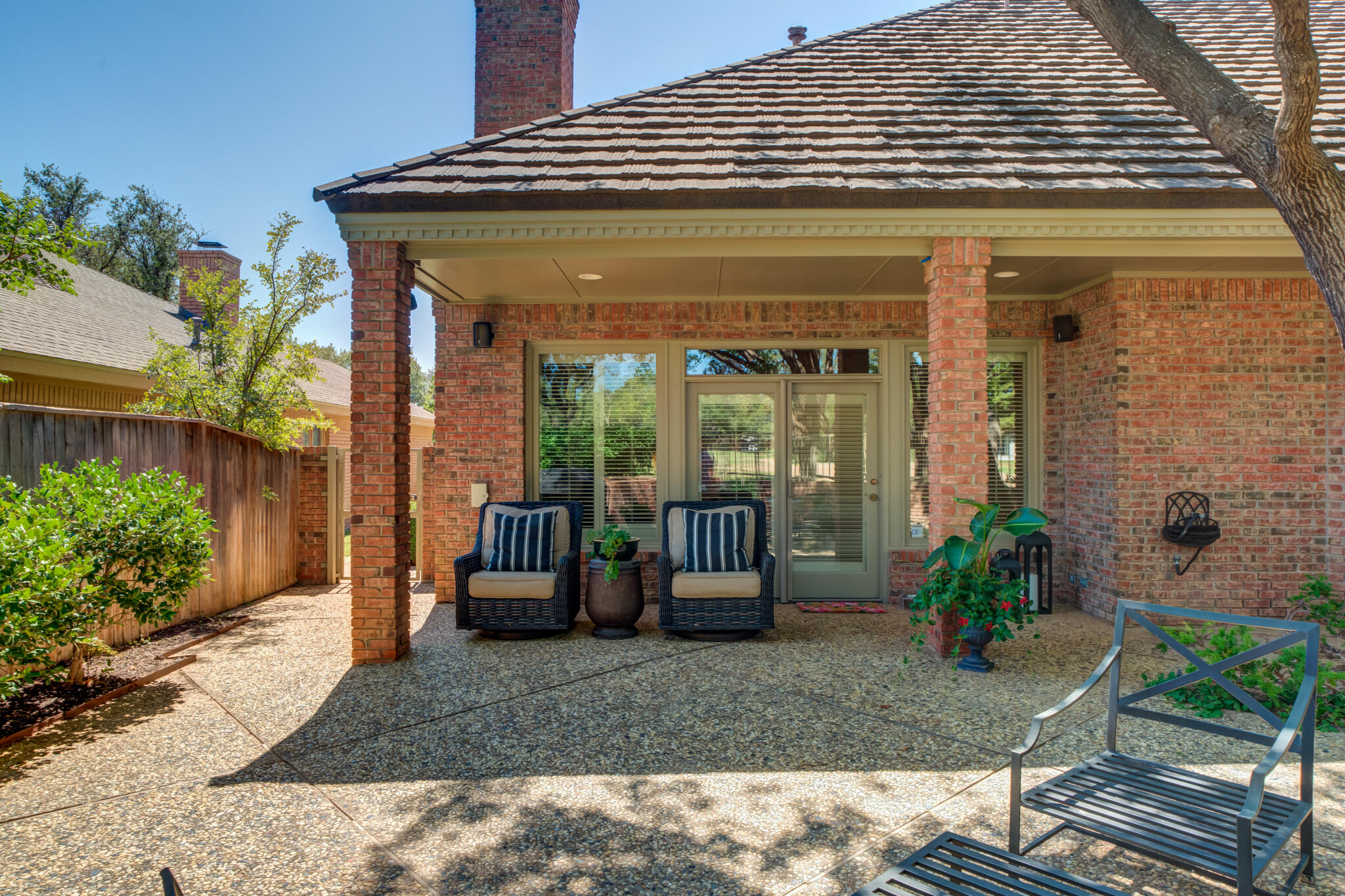 4612 91st Street Lubbock, TX 79424 - Photo 77 of 83 a view of a patio with table and chairs potted plants and floor to ceiling window