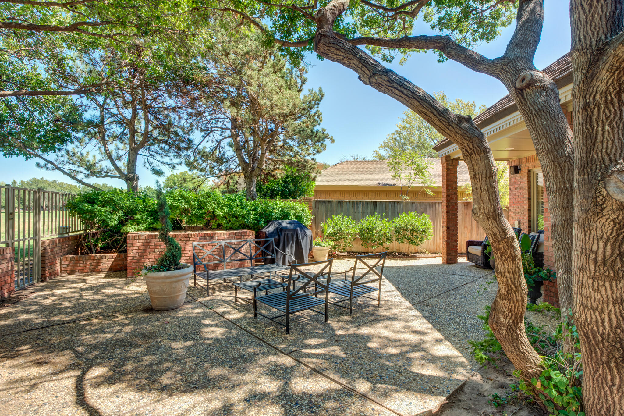 4612 91st Street Lubbock, TX 79424 - Photo 82 of 83 a view of a patio with table and chairs potted plants and large tree