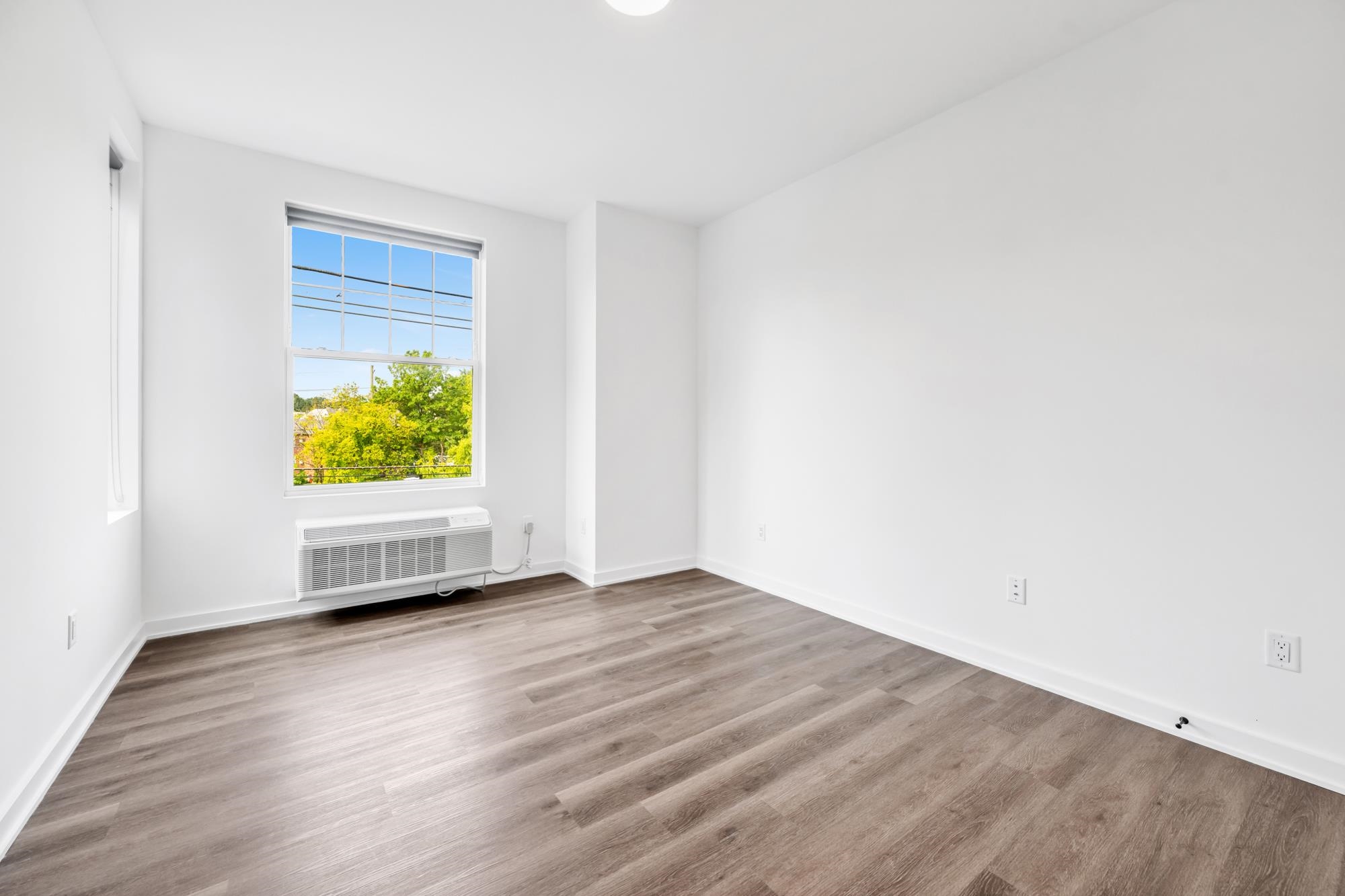 315 Railroad Avenue, Unit 204 East Rutherford, NJ 07073 - Photo 16 of 29 an empty room with wooden floor and windows