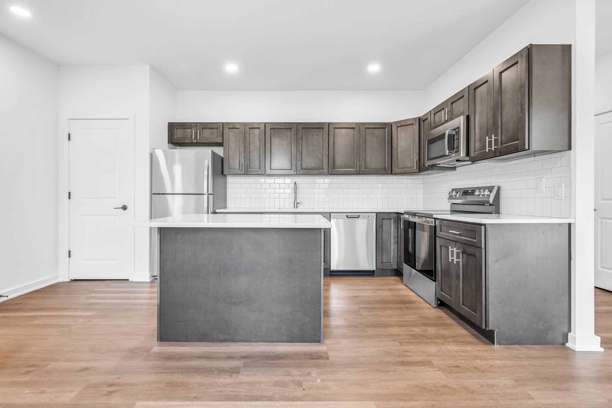 315 Railroad Avenue, Unit 204 East Rutherford, NJ 07073 - Photo 4 of 29 a kitchen with stainless steel appliances granite countertop a stove a sink and a refrigerator