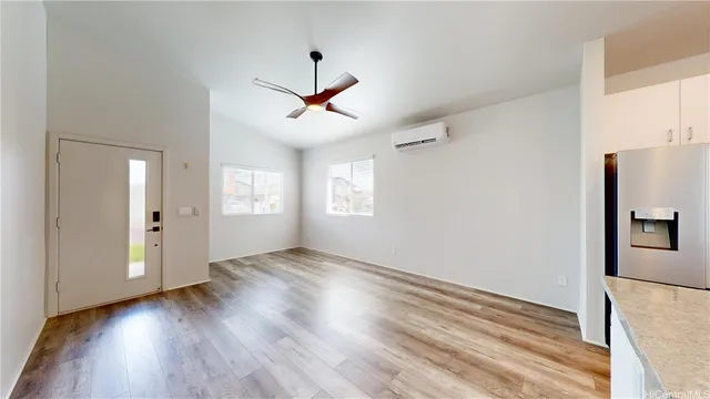 a view of an empty room with window and wooden floor