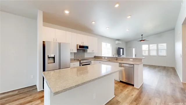 a large kitchen with kitchen island a large counter space a sink appliances and cabinets