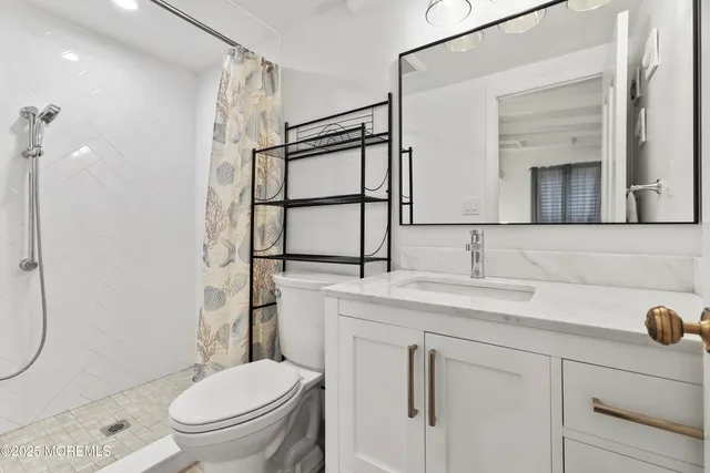 a bathroom with a granite countertop sink toilet and shower
