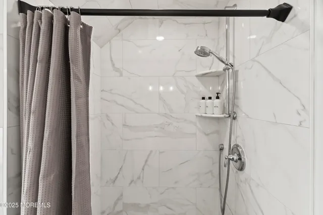 a bathroom with a shower and a glass door