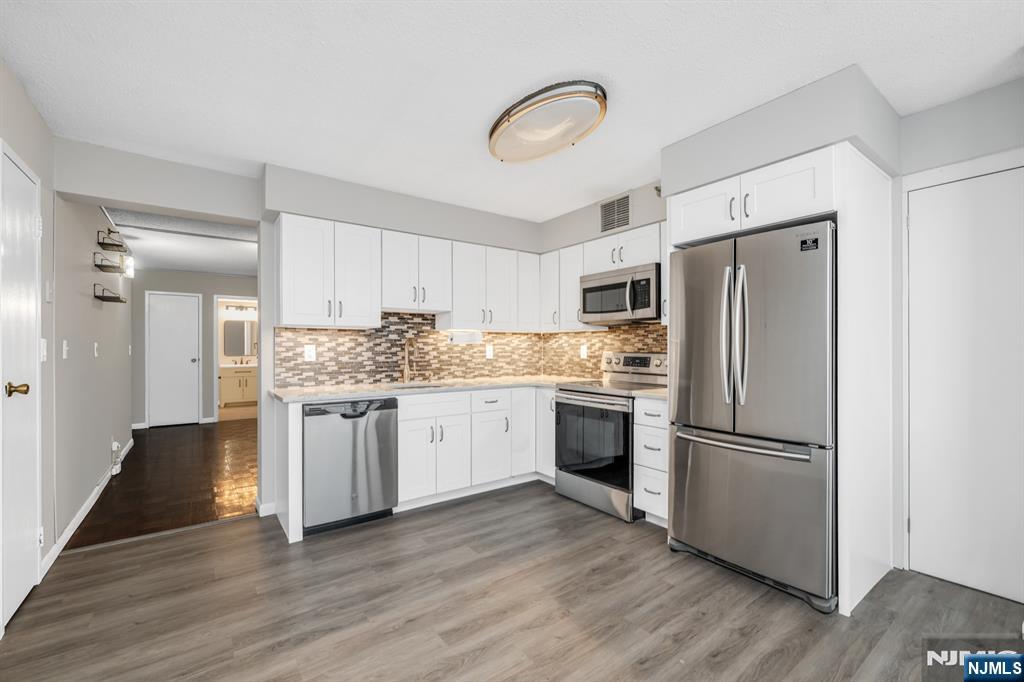 326 Prospect Avenue, Unit 8E Hackensack, NJ 07601 - Photo 7 of 20 a kitchen with a refrigerator cabinets and wooden floor