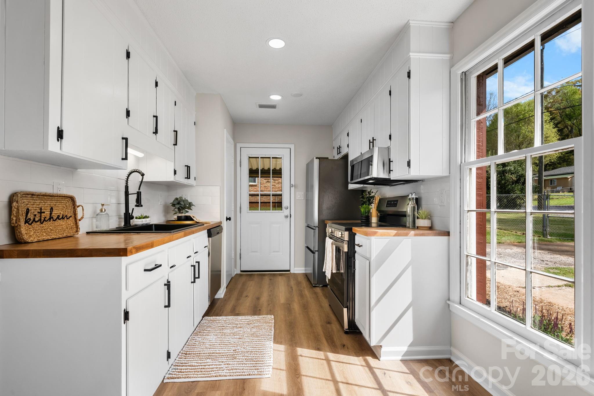 1307 6th Avenue Northwest Conover, NC 28613 - Photo 6 of 17 a kitchen with white cabinets and sink