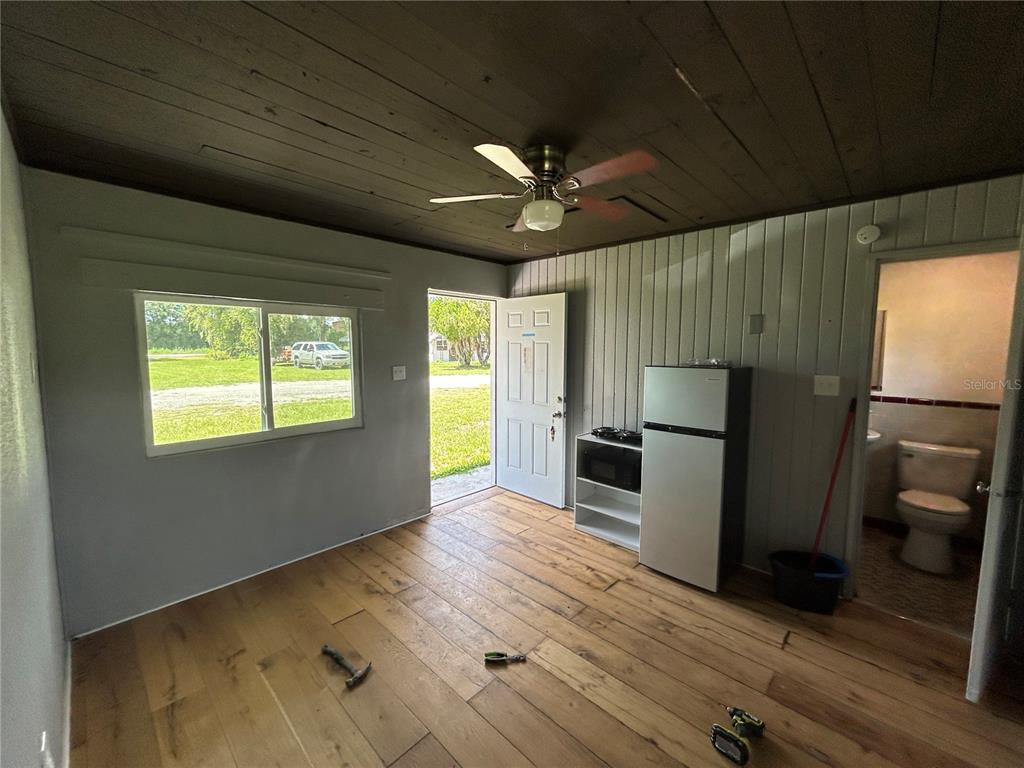 8010 Southeast Us Highway Hawthorne, FL 32640 - Photo 16 of 22 a view of a kitchen with a refrigerator a sink a ceiling fan and wooden floor