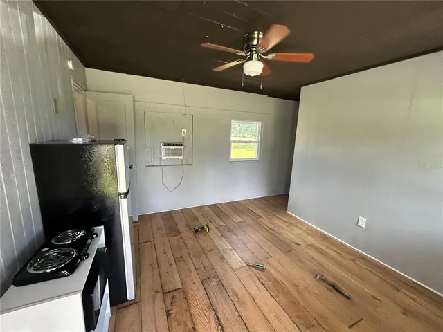 a kitchen with a wooden floor and a refrigerator