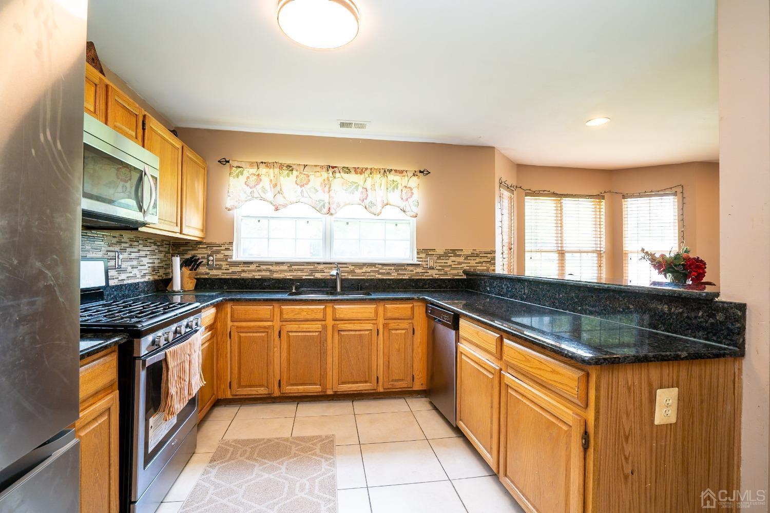 63 Springfield Road North Brunswick, NJ 08902 - Photo 14 of 42 a large kitchen with granite countertop a sink and a stove