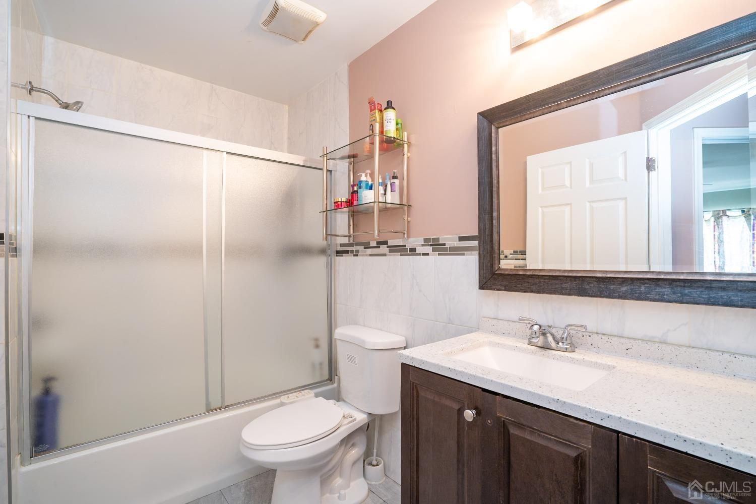 63 Springfield Road North Brunswick, NJ 08902 - Photo 24 of 42 a bathroom with a granite countertop sink toilet and shower