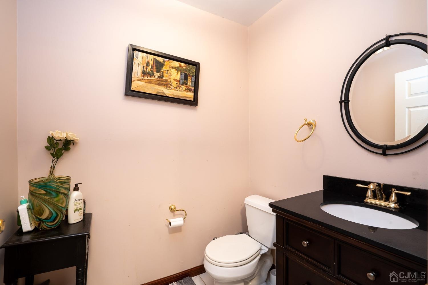 63 Springfield Road North Brunswick, NJ 08902 - Photo 7 of 42 a bathroom with a granite countertop toilet a sink and a mirror