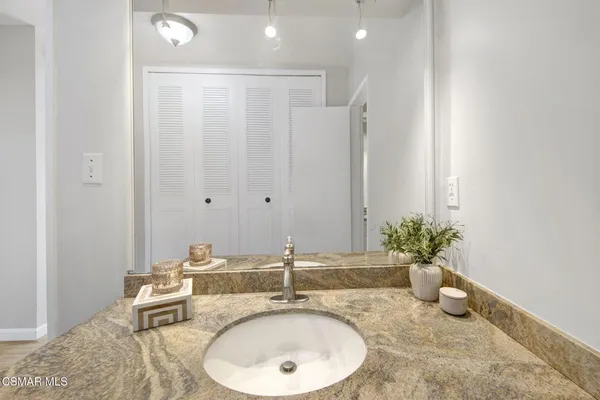 a bathroom with a granite countertop sink and a mirror