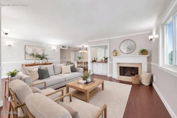 a living room with furniture a fireplace and a large window
