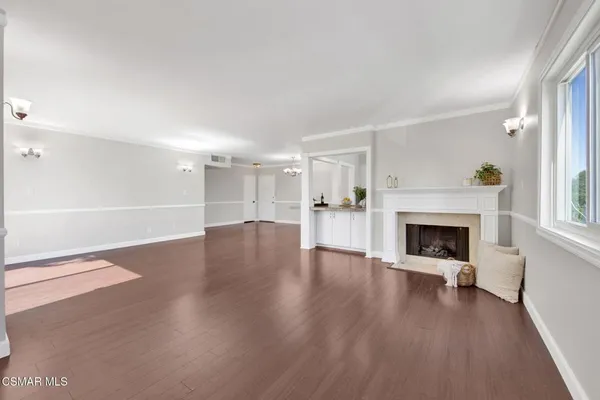 a view of a livingroom with wooden floor and a fireplace