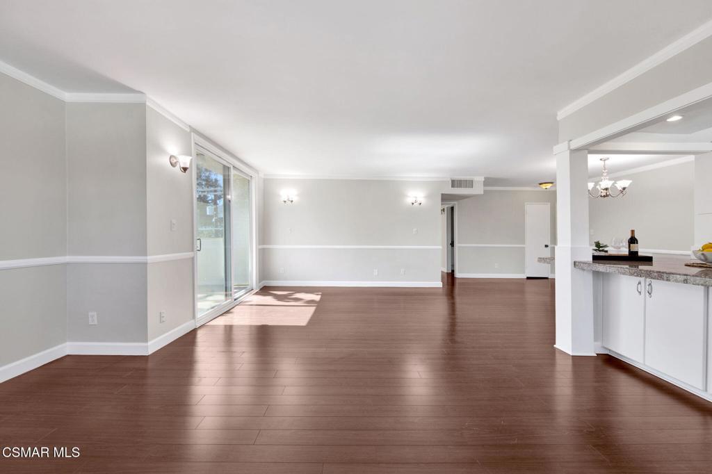 12955 Riverside Drive, Unit 307 Sherman Oaks, CA 91423 - Photo 7 of 24 a view of an empty room with wooden floor and a kitchen