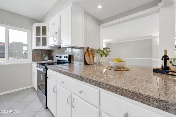 a kitchen with granite countertop a sink a stove and cabinets