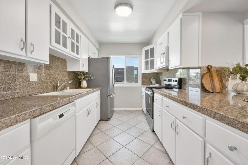 12955 Riverside Drive, Unit 307 Sherman Oaks, CA 91423 - Photo 10 of 24 a large white kitchen with granite countertop a sink
