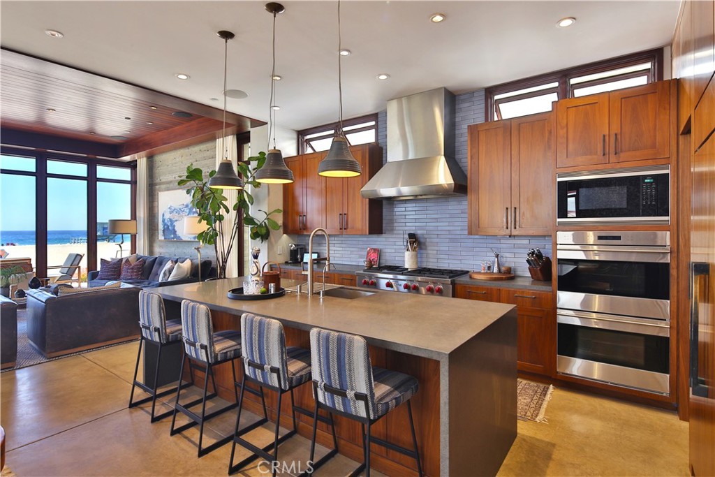 3124 The Strand Hermosa Beach, CA 90254 - Photo 8 of 28 a kitchen with stainless steel appliances a stove a sink a microwave a refrigerator and chairs