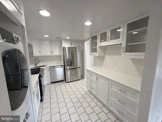 a kitchen with stainless steel appliances a refrigerator sink and cabinets