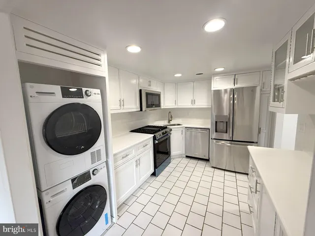 a kitchen with a refrigerator sink and cabinets