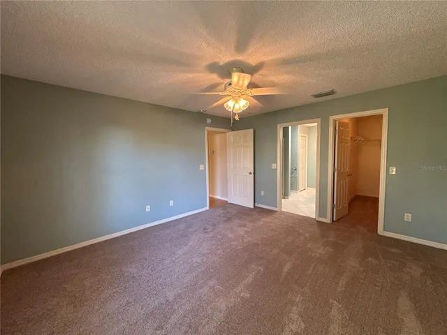an empty room with a ceiling fan and a window