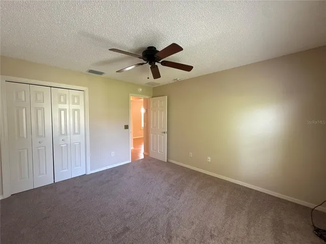 a view of an empty room and a ceiling fan