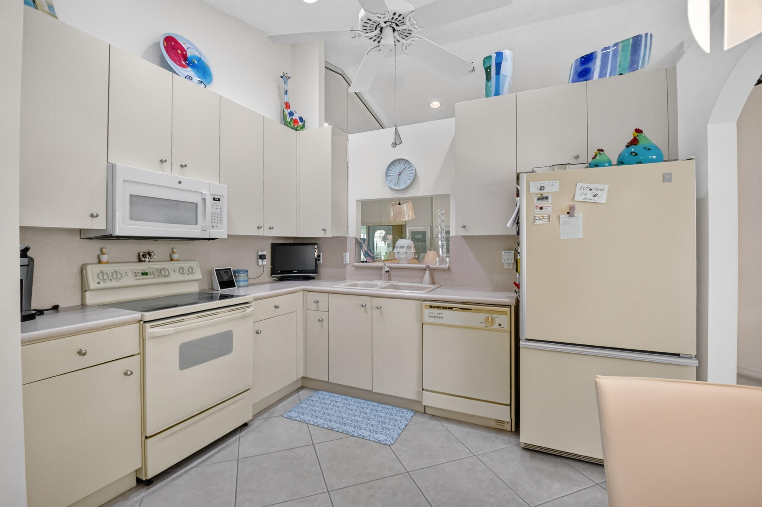 15340 Floral Club Road Delray Beach, FL 33484 - Photo 12 of 42 a kitchen with cabinets and white appliances