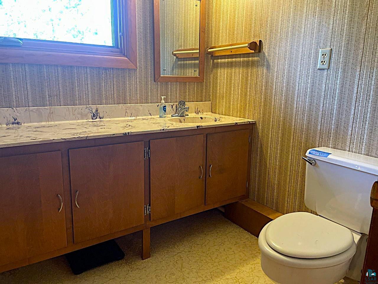 1480 Maijala Road Ely, MN 55731 - Photo 31 of 58 Bathroom featuring a spacious vanity with a built-in sink, ample storage cabinetry, and a window providing natural illumination